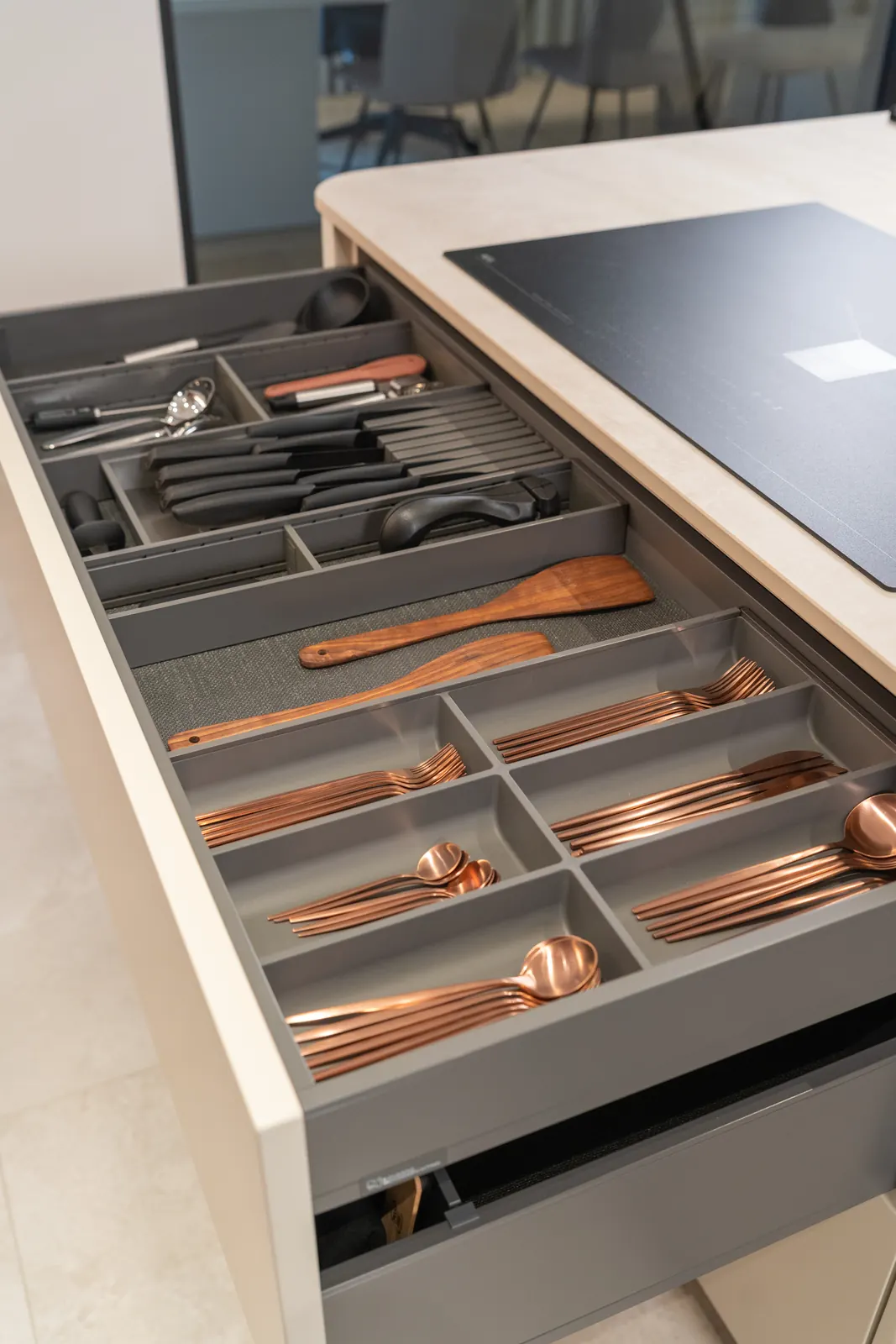 Besteklade met koperkleurig bestek en houten keukengerei