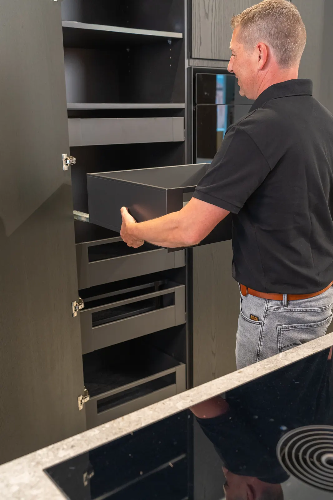 Wim plaatst een binnenlade in een hoge kast